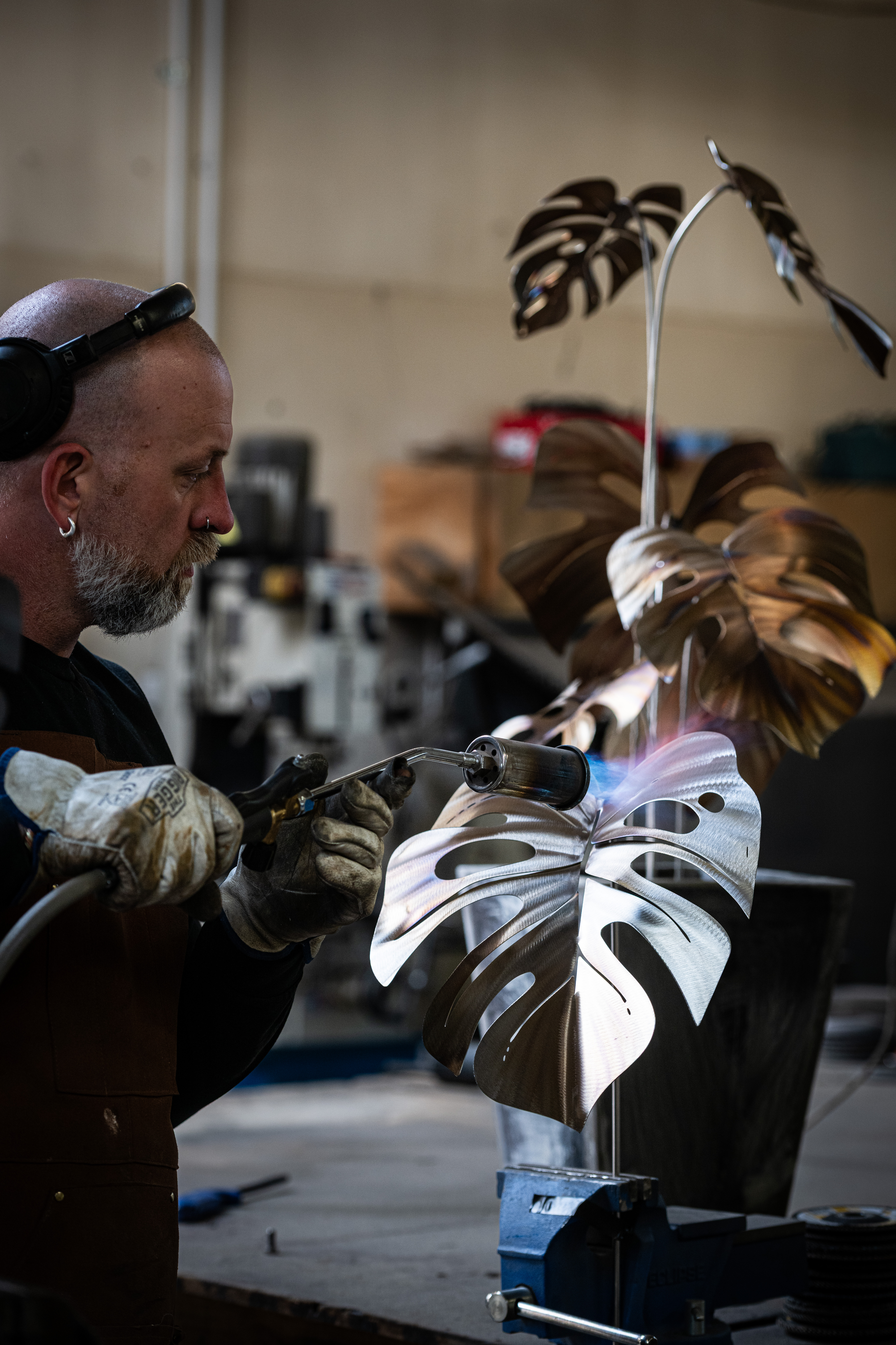 Artist torching a large monstera leaf